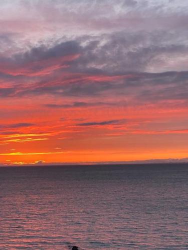 a sunset over a body of water with the ocean at Premium apartment Queen downtown in Reykjavík