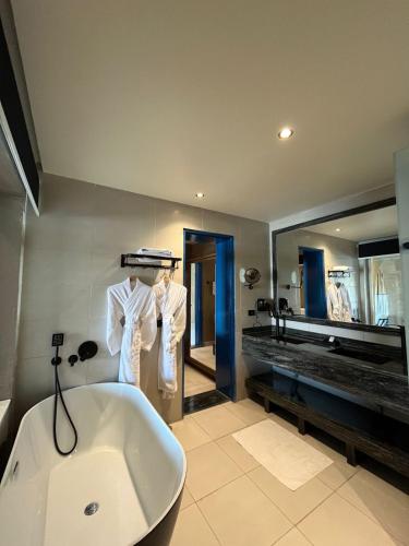 a bathroom with a bath tub and a large mirror at venecia Resort Fayoum in Al Ḩammām