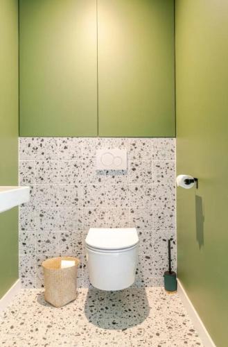 a bathroom with a toilet and a green wall at Olaf in Lyon