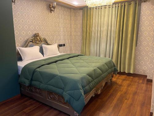 een slaapkamer met een bed met een groen dekbed bij Kamisama Boutique Stay in Vagator