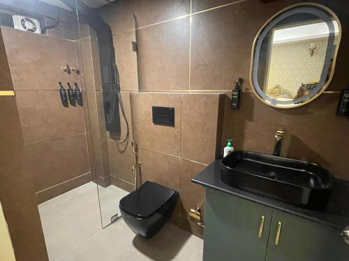 een badkamer met een wastafel, een toilet en een spiegel bij Kamisama Boutique Stay in Vagator