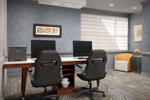 an office with a desk with two monitors and two chairs at Homewood Suites by Hilton Alexandria in Alexandria