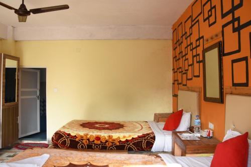 a hotel room with two beds and a table at Hong Qi Hotel in Chitwan
