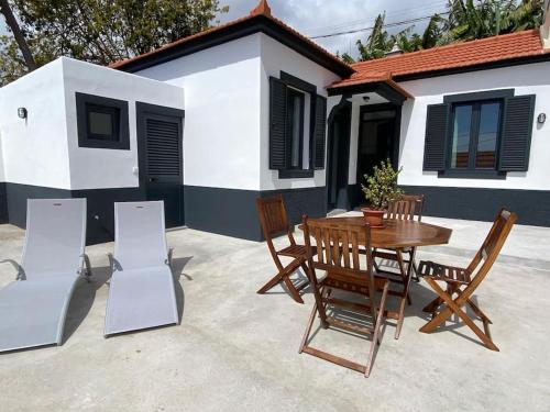 a wooden table and chairs in front of a house at Casa Isa - Funchal in Funchal