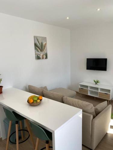 a living room with a table with a bowl of fruit on it at Casa Isa - Funchal in Funchal