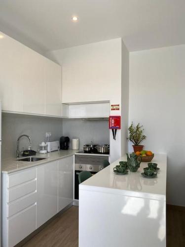 a kitchen with white cabinets and a white counter top at Casa Isa - Funchal in Funchal