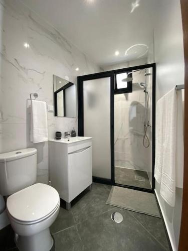 a white bathroom with a toilet and a shower at Casa Isa - Funchal in Funchal