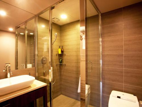 een badkamer met een douche en een wastafel bij Hotel Hamahigashima Resort in Uruma