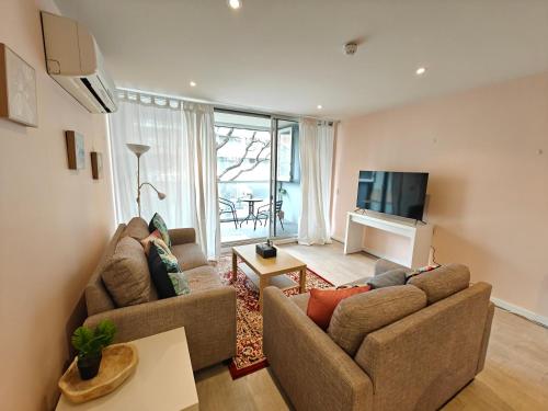 a living room with two couches and a television at Luxury 2BR apartment in the heart of CBD in Adelaide
