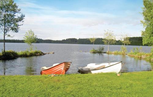 two boats sitting on the shore of a lake at Holiday Home Flattinge Vittaryd V in Kvänarp