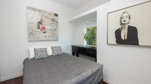 a bedroom with a bed and a picture on the wall at Hampton Court Apartments in Brisbane