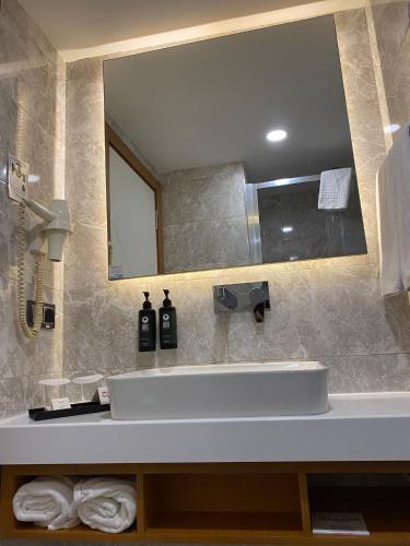 a bathroom with a sink and a mirror at Ramada By Wyndham Giresun Piraziz in Piraziz