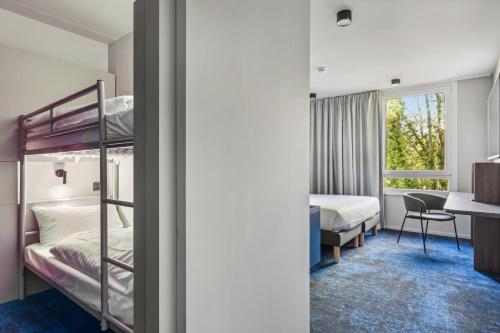 セリにあるHôtel AKENA Serris - Val d'Europeの二段ベッド、デスク、ベッドが備わる客室です。