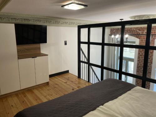 a bedroom with a bed and a large window at Pod Błękitnymi Podkowami in Wrocław