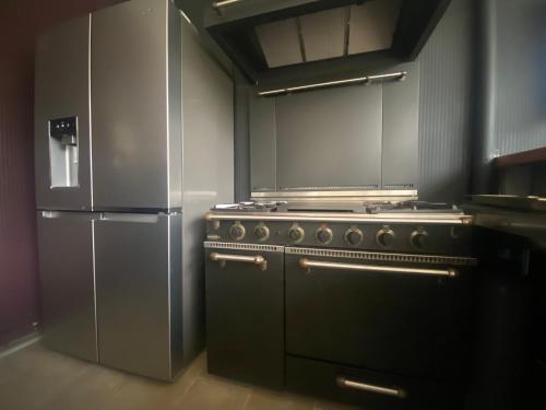 une cuisine avec une cuisinière et un réfrigérateur dans l'établissement Grande villa de charme bords de Seine proche Paris, à Louveciennes