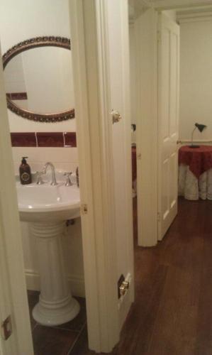 a bathroom with a sink and a mirror at Annies Garden Cottage in Hobart