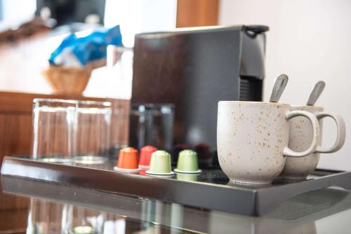a counter with two coffee cups on a shelf at Holiday Inn Newcastle South by IHG in Boldon