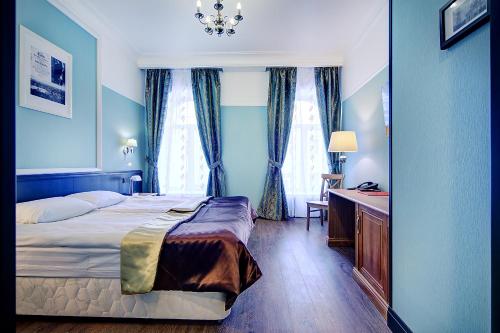 una camera d'albergo con letto e scrivania di Elegia a San Pietroburgo
