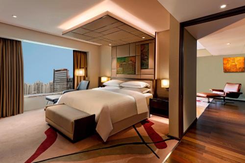 a bedroom with a large bed and a large window at Sheraton Grand Bengaluru Whitefield Hotel & Convention Center in Bangalore