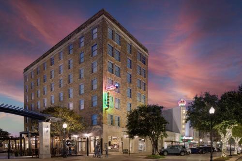 a tall building with a flag on top of it at The LaSalle Hotel, Bryan College Station, a Tribute Portfolio Hotel in Bryan