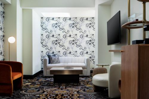 a living room with a couch and a tv at The LaSalle Hotel, Bryan College Station, a Tribute Portfolio Hotel in Bryan