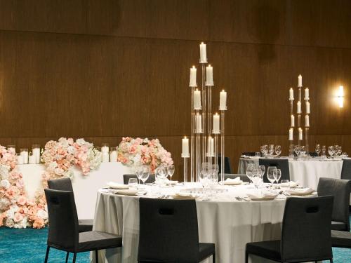 a dining room with tables and chairs and flowers at Novotel Melbourne Airport in Melbourne