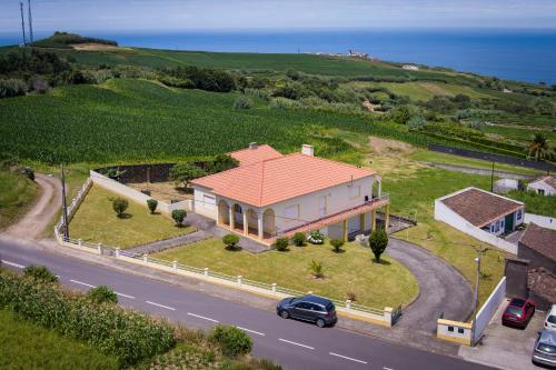 a house with a car parked in front of it at Casa dos cinco sentidos in Feteira Pequena
