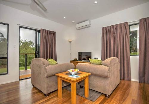a living room with two chairs and a table at Eumundi Cottages - Cottage 1 in Eumundi