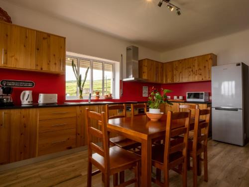 a kitchen with a wooden table and a refrigerator at Casa dos cinco sentidos in Feteira Pequena