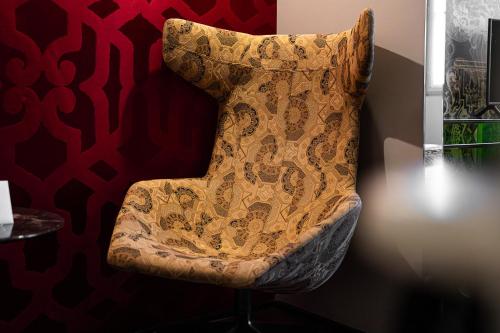 a chair sitting in a room next to a wall at Hôtel du Petit Moulin, Haute Couture hotel by Lacroix in Paris