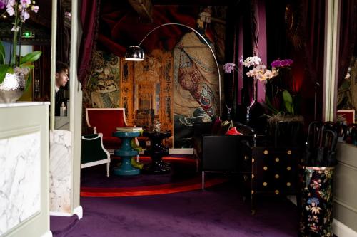a room filled with lots of chairs and a table at Hôtel du Petit Moulin, Haute Couture hotel by Lacroix in Paris