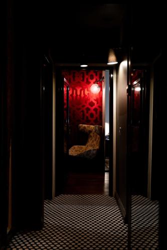 an open door to a dark room with a light at Hôtel du Petit Moulin, Haute Couture hotel by Lacroix in Paris