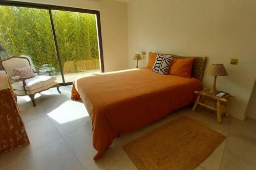 une chambre avec un grand lit et une grande fenêtre dans l'établissement Appartement Indépendant avec Jardin et Piscine en Provence, à Ventabren