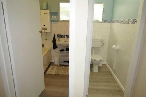 a small bathroom with a sink and a toilet at Whispering Woods Cottage in Natureʼs Valley
