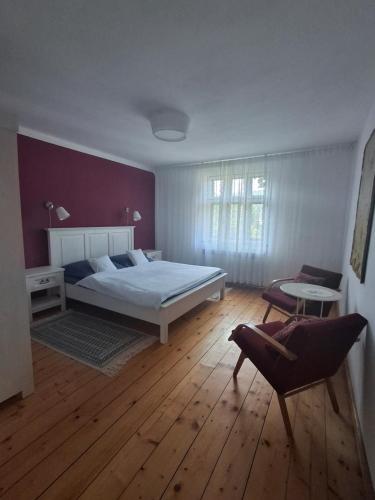 a bedroom with a bed and a chair at Dům u rybníka in Nýdek