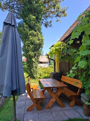 an umbrella sitting next to a wooden table and bench at Dům u rybníka in Nýdek