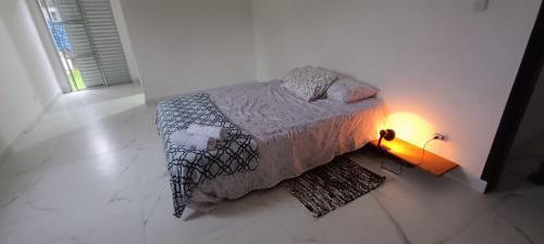 a bedroom with a bed with a light on it at 11Suites casa Suite #5 in Caraguatatuba