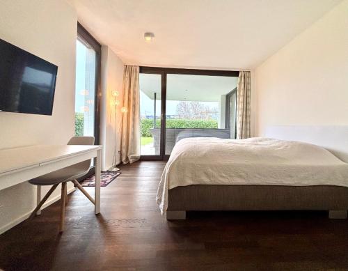 a bedroom with a bed and a desk and a window at Studio Apartment direkt am Phoenixsee in Dortmund