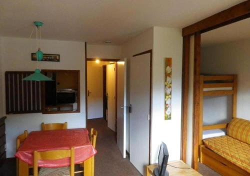 d'un salon avec une table et d'une chambre avec des lits superposés. dans l'établissement Grand studio 4 pers au pied des pistes - Wifi - parking, aux Orres