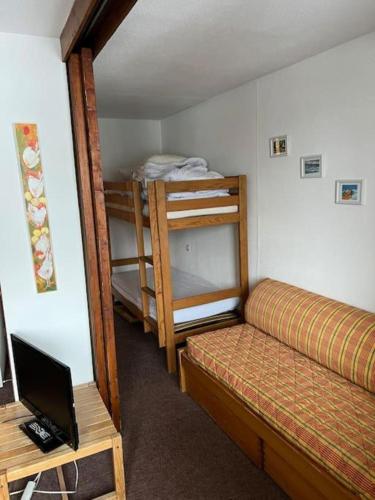 Cette chambre comprend 2 lits superposés et un bureau avec un ordinateur portable. dans l'établissement Grand studio 4 pers au pied des pistes - Wifi - parking, aux Orres