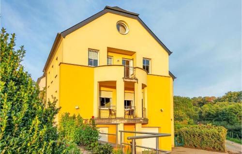 une maison jaune avec un balcon sur le côté. dans l'établissement 2 Bedroom Awesome Apartment In Winseler, à Winseler