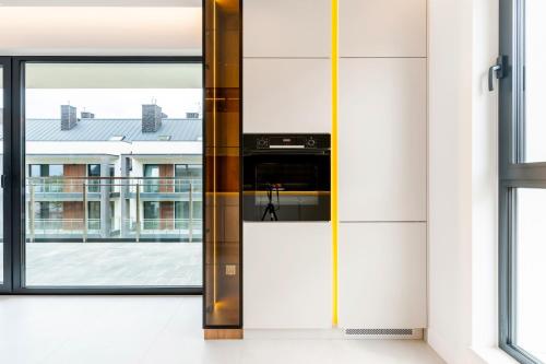 a glass door in a kitchen with a view of a building at Marina Ostróda - 80 metrów luksusu z widokiem na jezioro in Ostróda