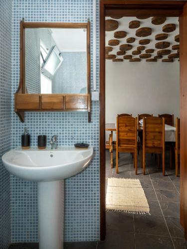 a bathroom with a sink and a dining room at Casinha dos cinco sentidos in Nordestinho