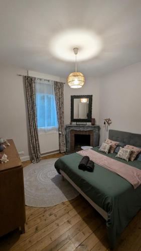 - une chambre avec un lit, une cheminée et un miroir dans l'établissement Villa des roses, comme à la maison, à Cherbourg en Cotentin