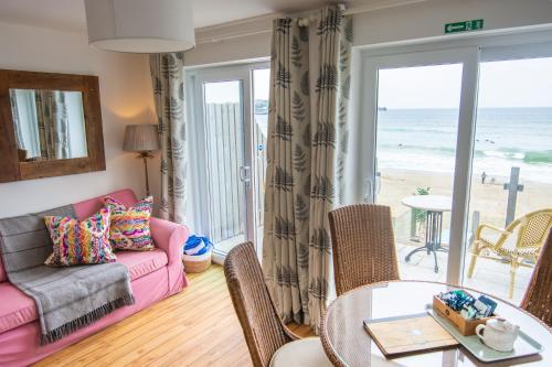 a living room with a couch and a table at Tolcarne Beach Apartments in Newquay