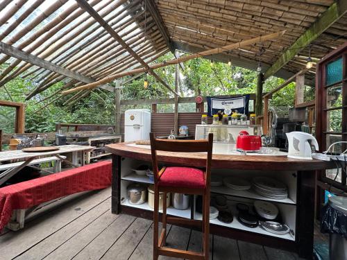 an outdoor kitchen with a table and chairs on a deck at Stormsriver Backpackers Dijembe in Stormsrivier