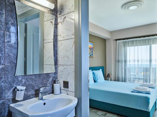 a bathroom with a sink and a bed and a mirror at Atel Villas in Xanthi