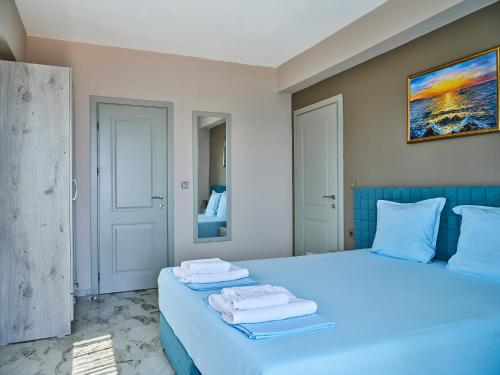 a bedroom with a blue bed with towels on it at Atel Villas in Xanthi