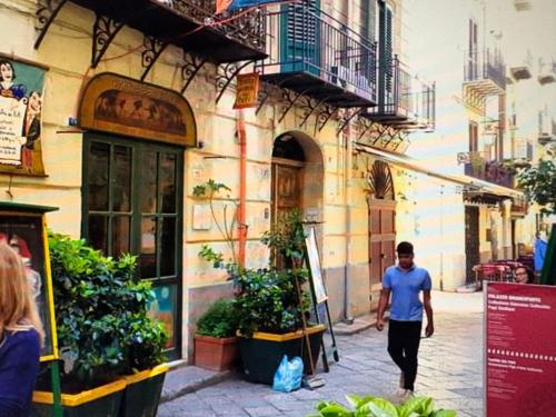 a man walking down a street in front of a building at Daniel's Winter in Palermo