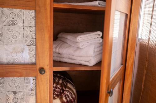 a wooden cabinet with towels in a room at Pousada Petit Refuge in Juquei